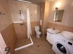 a bathroom with a toilet sink and a washing machine at Studio SeaDream in Primorsko