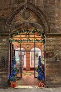 einen Eingang zu einem Backsteingebäude mit Blumen und Pflanzen in der Unterkunft I Merli di Ada in Siena