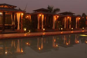 una piscina con velas en el agua por la noche en Hotel Chulhewala en Jhānsi