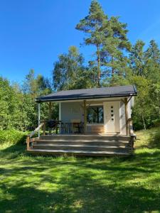a tiny house with a porch and a deck at Spjutås Gård in Öxabäck