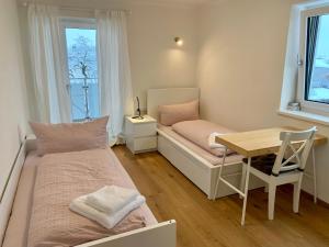 una camera con due letti, un tavolo e una finestra di Apartments Oliver, Axams a Innsbruck