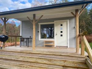 a tiny house with a porch and a grill at Spjutås Gård in Öxabäck