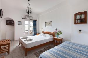 a bedroom with two beds and a table with flowers at DELFINI I in Fira