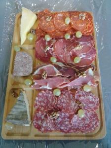 a plate of food with grapes and meat and cheese at Maison de bourg in Vic-le-Comte