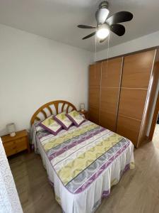 een slaapkamer met een bed en een plafondventilator bij DARISOL in Santa Pola
