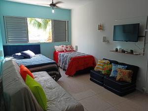 sala de estar con sofá y TV en Kit Relu en Praia Grande
