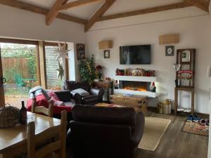 sala de estar con sofá y chimenea en Charming Gnome Cottage in Devon near Sidmouth, en Ottery St Mary