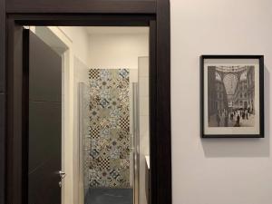 un corridoio con specchio e foto appese a un muro di FondacOlivella a Napoli