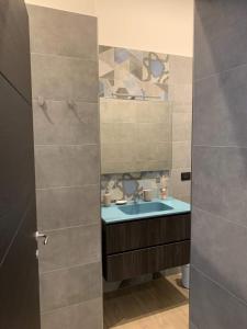 un bagno con lavandino e porta doccia in vetro di FondacOlivella a Napoli