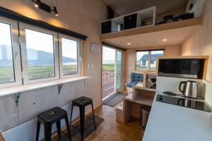 una cocina con dos taburetes en una casa pequeña en Tiny Piece of Paradise - Te Anau Tiny House, en Te Anau