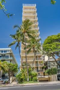 a tall building with palm trees in front of it at @ Marbella Lane -Coastal retreat near Diamond Head in Honolulu