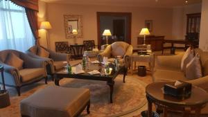 a living room with couches and chairs and a table at Abha Palace Hotel in Abha
