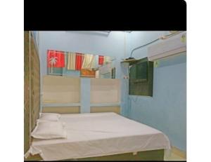 a small hospital room with a bed and towels at Hotel Good Will, Prayagraj in Muthiganj