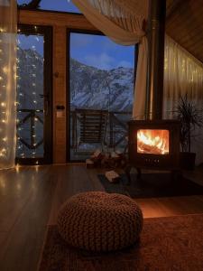 a fireplace in a room with a view of a mountain at Cottage Toladi in Kazbegi