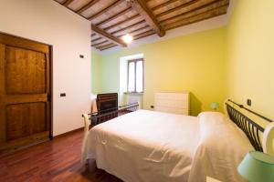 una camera con un letto bianco e una porta in legno di Villa degli Orti ad Acqualagna