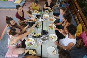 a group of people sitting around a table eating food at GoYm Resort in Arambol