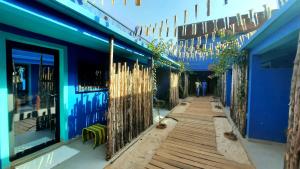 un couloir d'un bâtiment bleu avec une clôture dans l'établissement L'Hédone, hôtel de charme, à Ouagadougou