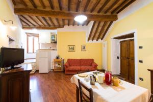 a living room with a table and a red couch at Villa degli Orti in Acqualagna