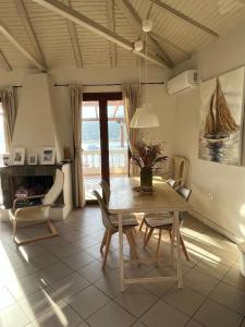 einen Esstisch und Stühle im Wohnzimmer in der Unterkunft Poros endless view apartment in Poros
