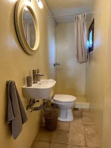 een badkamer met een wastafel, een toilet en een spiegel bij Poros endless view apartment in Poros
