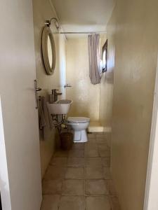 ein Badezimmer mit einem WC, einem Waschbecken und einem Spiegel in der Unterkunft Poros endless view apartment in Poros