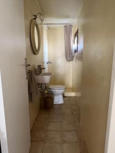 a bathroom with a toilet and a sink and a mirror at Poros endless view apartment in Poros