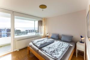 ein Schlafzimmer mit einem Bett und einem großen Fenster in der Unterkunft Ferienwohnung Wattkönig in Wyk auf Föhr