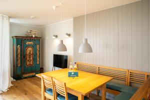 ein Esszimmer mit einem Holztisch und einem TV in der Unterkunft Ferienwohnung Wattkönig in Wyk auf Föhr