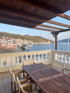 una mesa y sillas en un balcón con vistas al agua en Poros endless view apartment en Poros