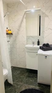 a white bathroom with a sink and a mirror at Lovely apartment with parking on closed premises. in Pärnu