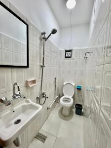 a white bathroom with a toilet and a sink at Euphoria bed & breakfast in Wadi Musa