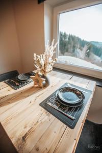 una mesa de madera con un plato y una ventana en # A Mont Nos'Hôtes en Malmedy