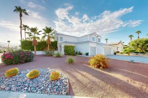 a large white house with palm trees and plants at Carlotta Haven in Palm Desert