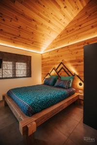 a bed in a room with a wooden ceiling at # A Mont Nos'Hôtes in Malmedy