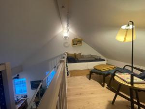 uma escada num quarto com uma cama e um candeeiro em Das blaue Haus - ein Sommertraum und ein Wintermärchen em Weiler-Simmerberg