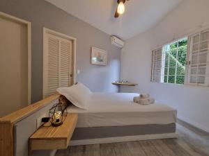 Un dormitorio con una cama grande y una ventana en Casas com jacuzzi e churrasqueira a 500 metros da Praia do Perequê na Ilhabela, en Ilhabela