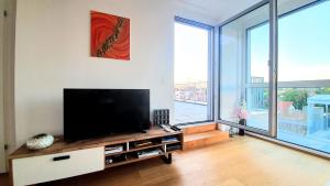 A television and/or entertainment centre at Rooftop Terrace, free garage parking and Pool!