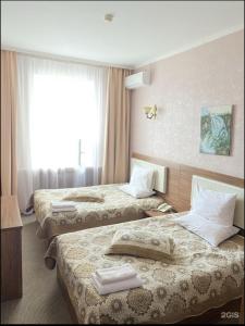 a hotel room with three beds and a window at KORSAR in Astana