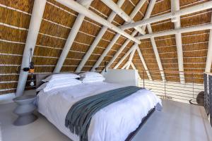 Schlafzimmer mit einem Bett mit weißer Bettwäsche und einer Holzdecke in der Unterkunft Africa Lodge in Somerset West + 90 Fotos