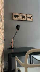 einen Schreibtisch mit einer Lampe und einem Bild an der Wand in der Unterkunft POBUUDKA II Plebańska z widokiem na Rynek in Gliwice