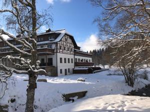 a large building in the snow with a tree at Strunzova Pila - apartmány s wellness 2,06 a 3,03 in Kvilda