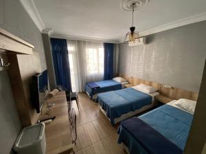 Habitación de hotel con 2 camas y TV en Köşk Hotel, en Antalya