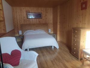 - une chambre avec un lit et une commode dans l'établissement La Ferme des Michaud, à Combloux