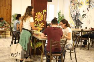 Eine Gruppe von Menschen, die in einem Raum an Tischen sitzen in der Unterkunft The Sydney Hotel in Amman + 23 Fotos