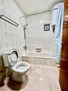 a bathroom with a toilet and a bath tub at Euphoria bed & breakfast in Wadi Musa