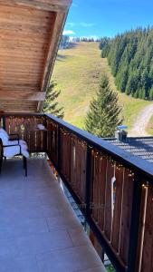 a wooden deck with a bench and a view of a field at Apartma Zala, Golte in Mozirska Koča