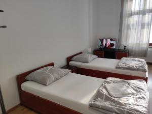 a room with two beds and a tv in it at Hostel 36 in Katowice