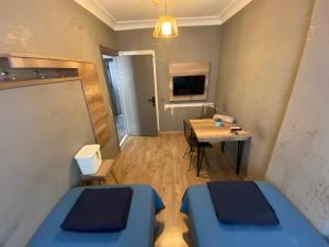 アンタルヤにあるKöşk Hotelのベッド2台とテーブルが備わる小さな客室です。