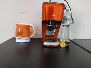 eine orangefarbene Kaffeemaschine auf einem schwarzen Tisch in der Unterkunft Hostel 36 in Kattowitz