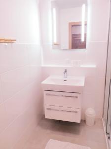 a white bathroom with a sink and a mirror at Appartement Fiffinjo in Piesendorf